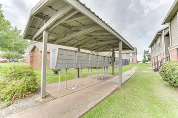 A covered walkway with a metal roof and concrete pillars.